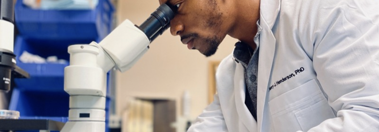 Henderson looking into microscope