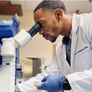 Henderson looking into microscope